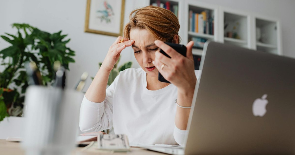 Persona revisando la factura del móvil junto a un router de fibra en casa